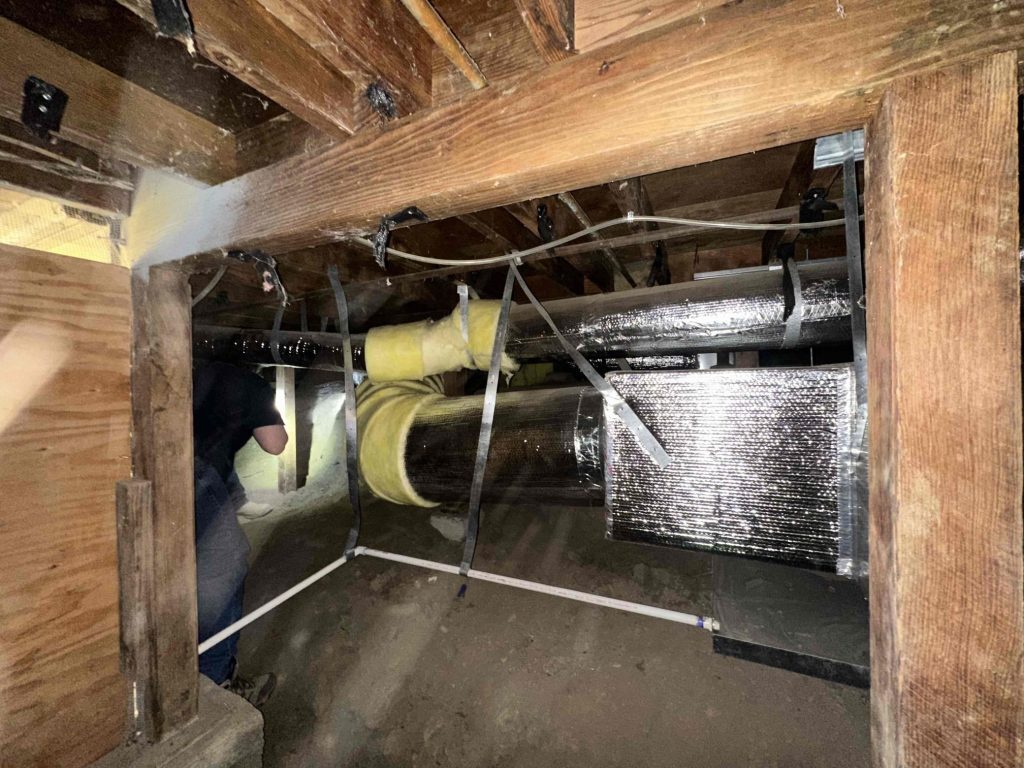 Person Inspecting Hard Metal Duct Installation