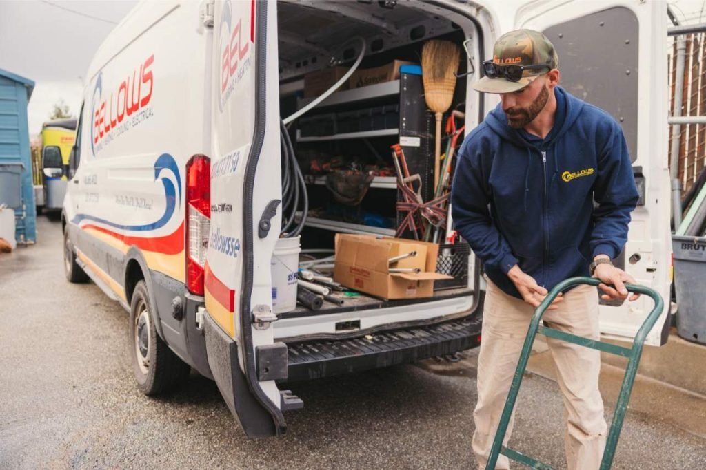 Electrician unloading tools from a service van