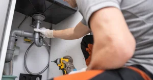 Plumber repairing a sink drain pipe