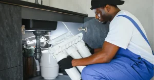 Certified technician conducting professional reverse osmosis maintenance and service on residential water filtration system